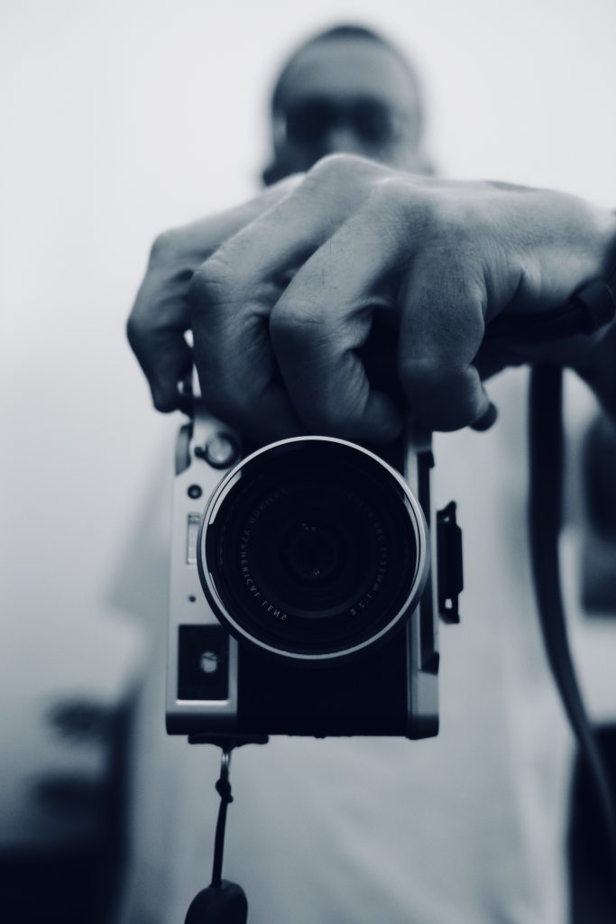 Trevor Chisman Photographer mirror selfie holding and shot with Fujifilm X100v